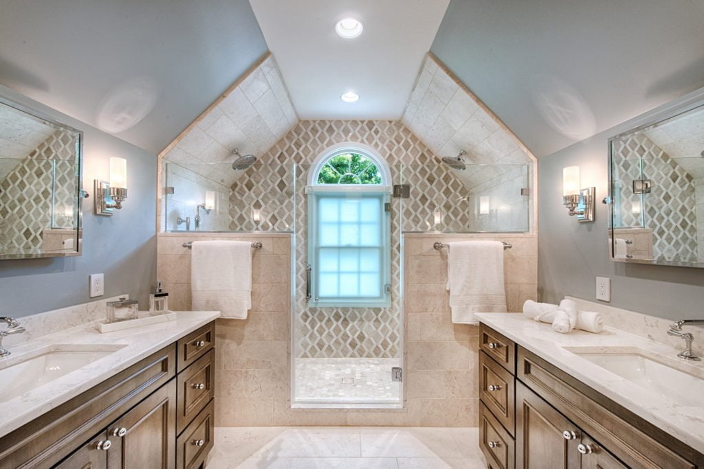 Luxurious double vanity master bathroom with walk-in shower and patterned tile